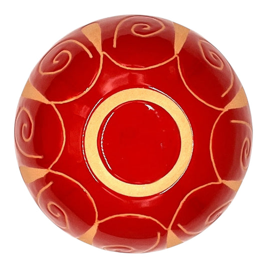 Dettaglio della base di una palla in ceramica rossa artigianale incisa, firmata Poz Studio Ceramiche, che mostra la lavorazione e il marchio artigianale.⁠